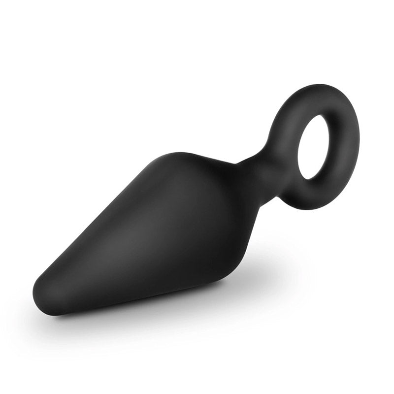 Black silicone butt plug with tapered tip and loop handle laying sideways on white background