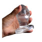 Hand squeezing XR Brands Master Series AF201 Anchored Clear Anal Plug together to demonstrate insertion size