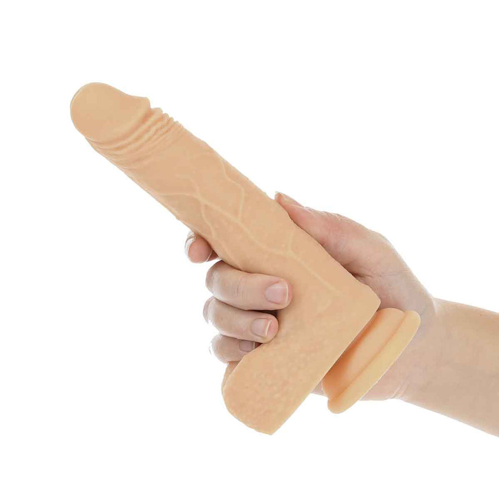 Hand holding a realistic beige silicone dildo with suction cup base on a white background