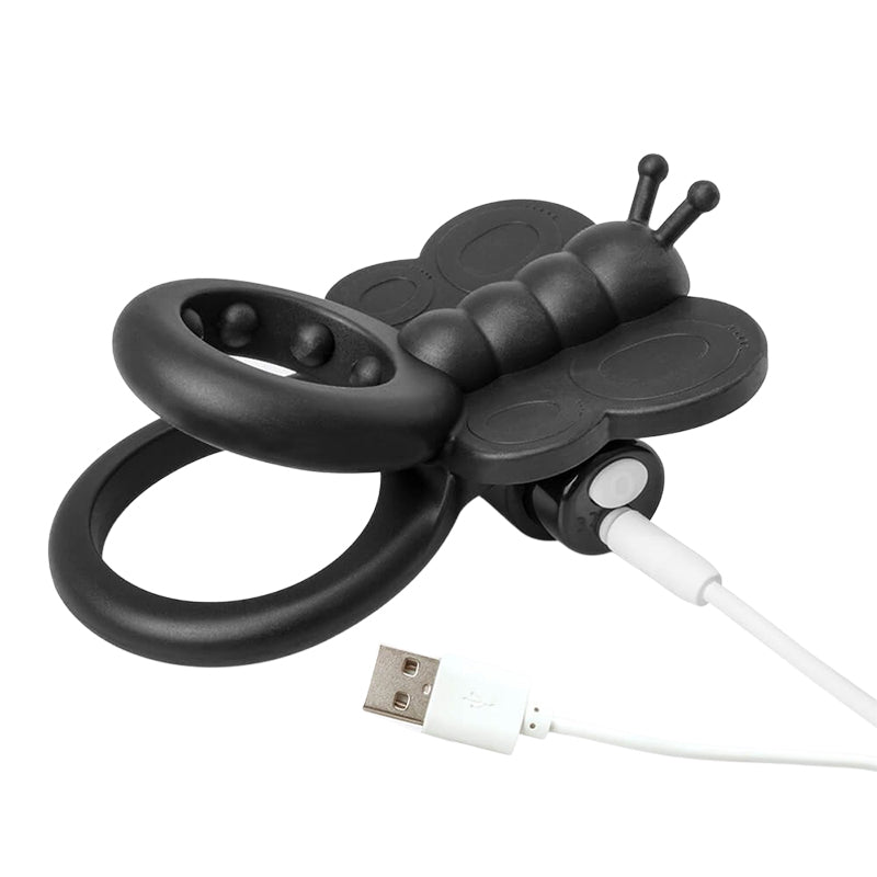 Black butterfly-shaped vibrating cock ring with USB charging cable on a white background