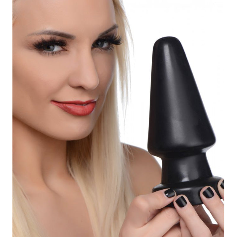 Woman holding a large black butt plug against a white background